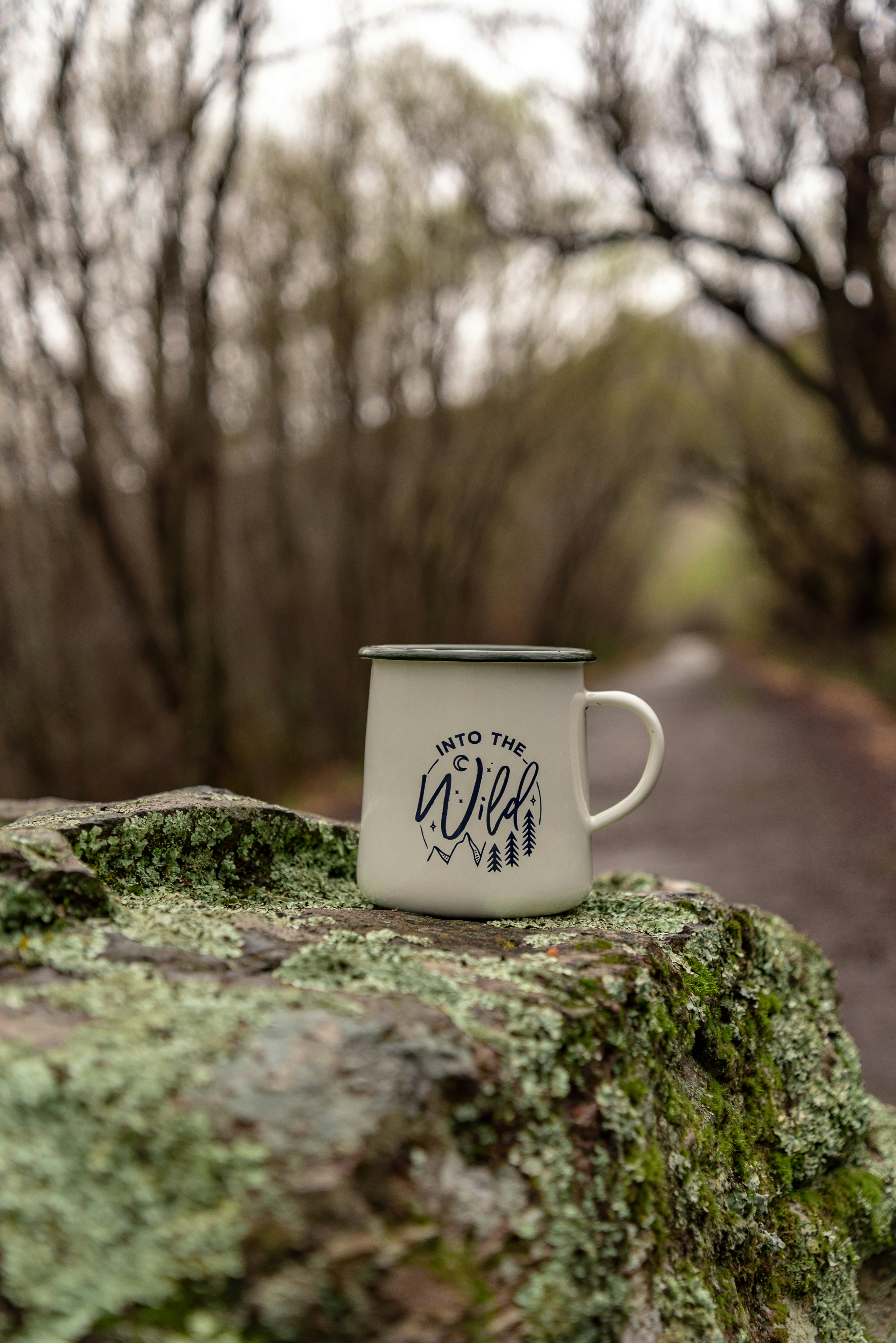 white and black mug on top of rock